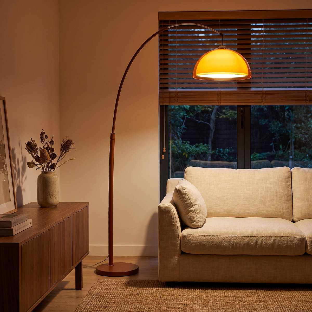Mid-Century Arc Floor Lamp with Amber Dome, switched on in a cozy interior at dusk