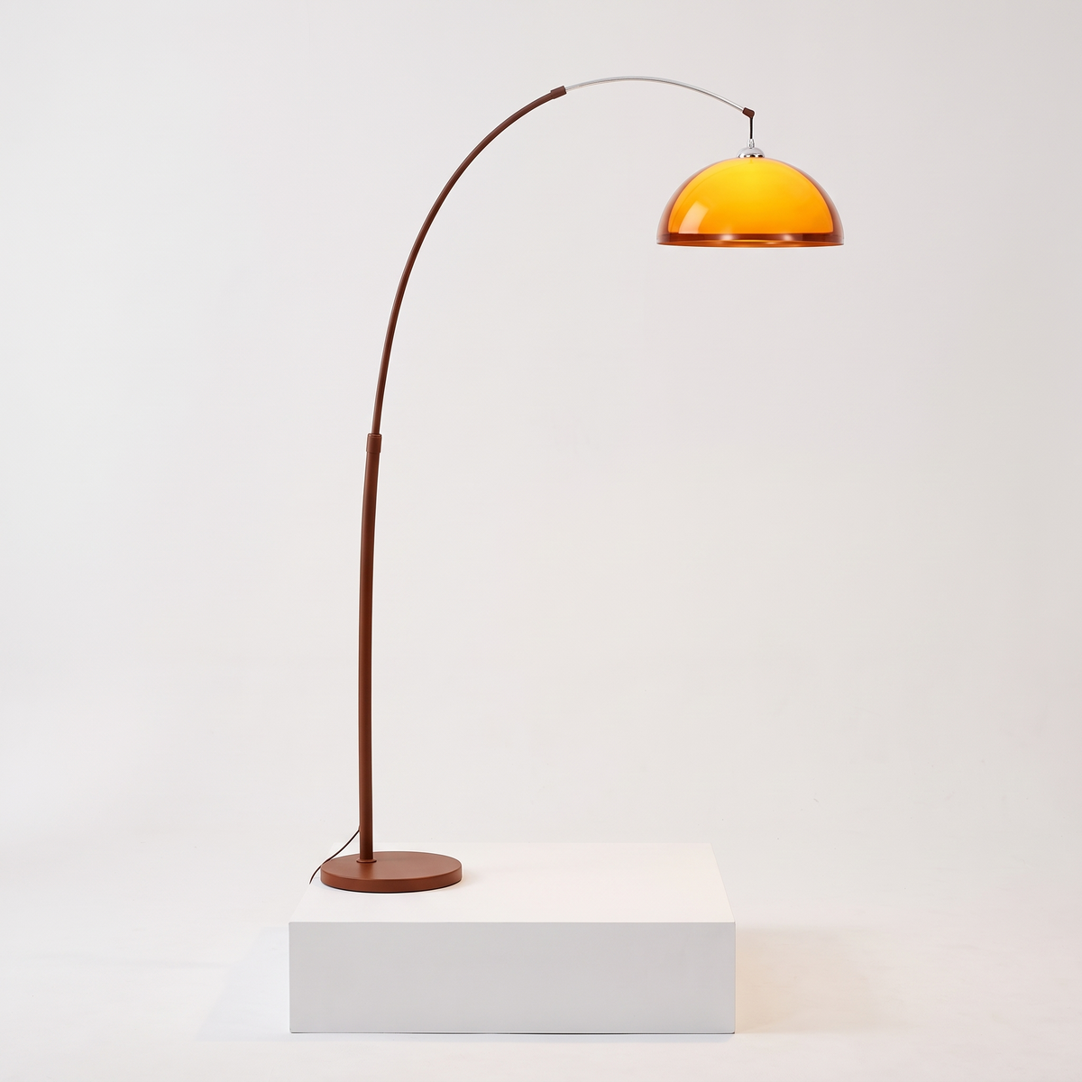 Mid-Century Arc Floor Lamp with Amber Dome on a white display plinth, full view