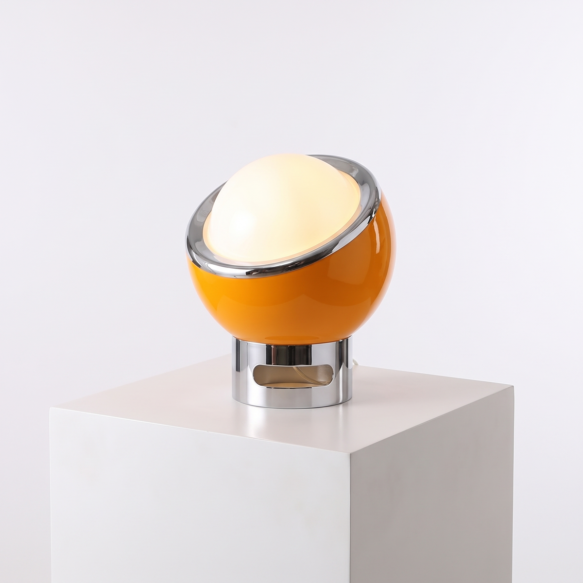Space Age Egg Table Lamp in Orange on a white display plinth