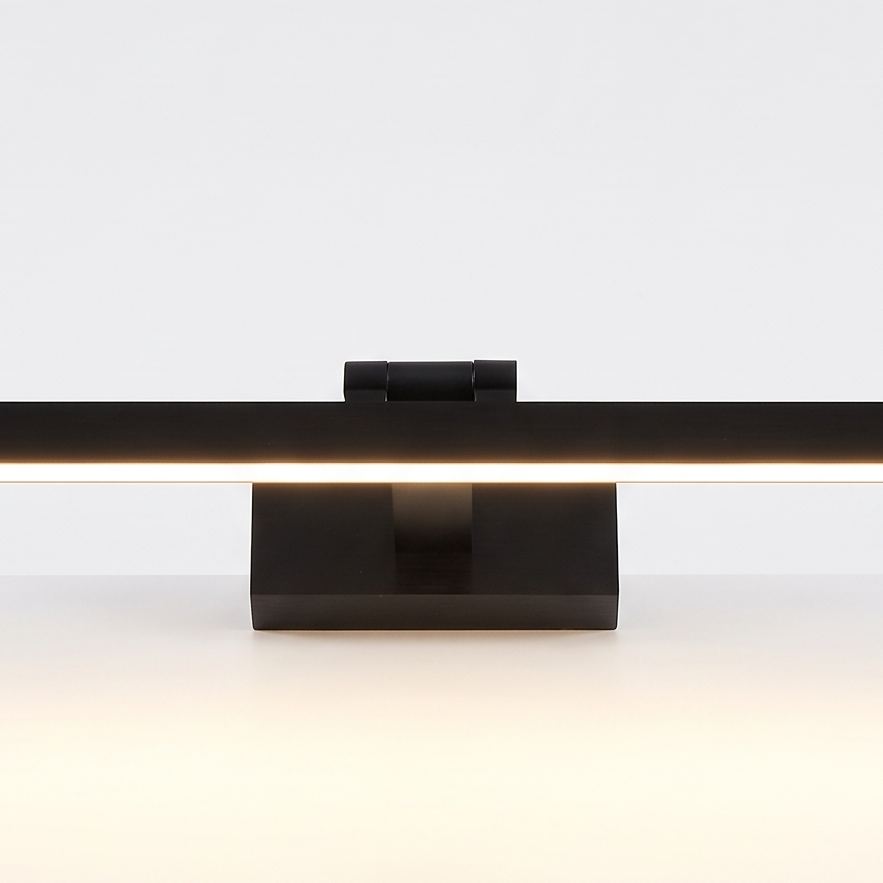 Brass LED Picture Light on a white display plinth, close up detail