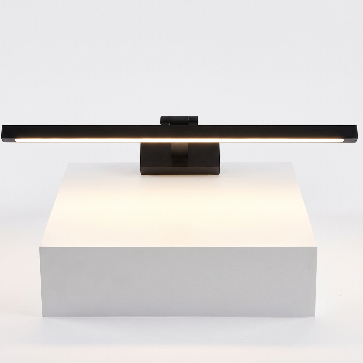 Brass LED Picture Light on a white display plinth, detail view