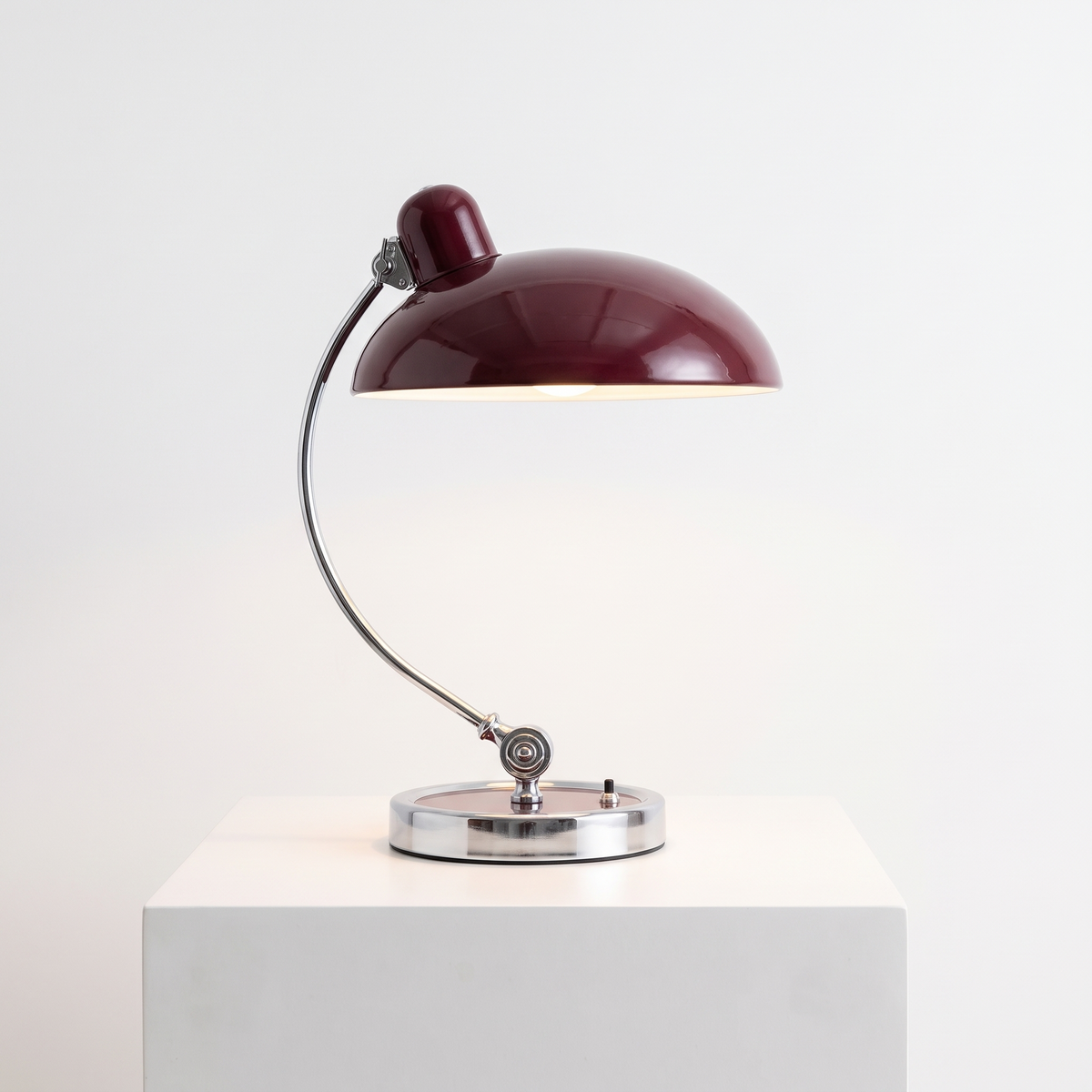 Bauhaus Mushroom Desk Lamp in Burgundy on a white display plinth